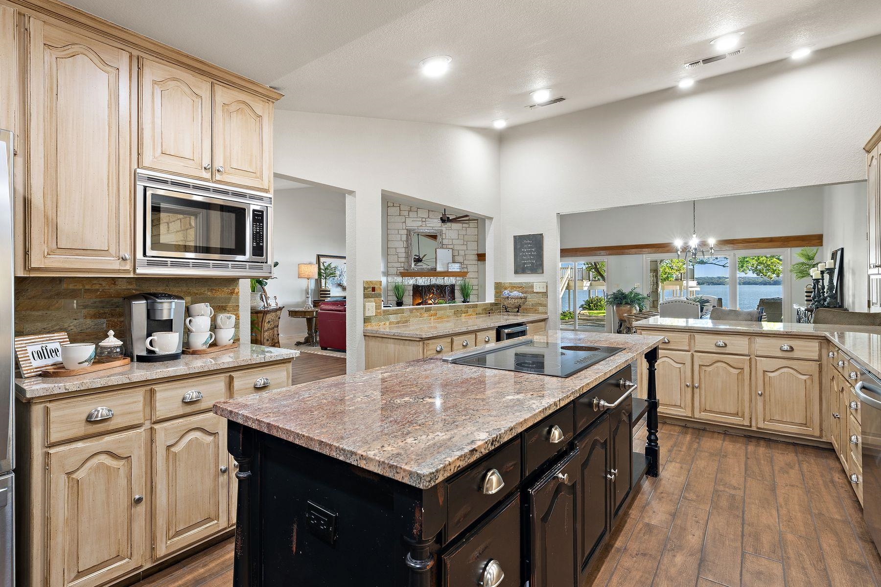 14 Beaver Island Road Granite Shoals, TX 78654 - Photo 23 of 30 a kitchen with stainless steel appliances granite countertop a kitchen island a stove a sink dishwasher and microwave with wooden floor