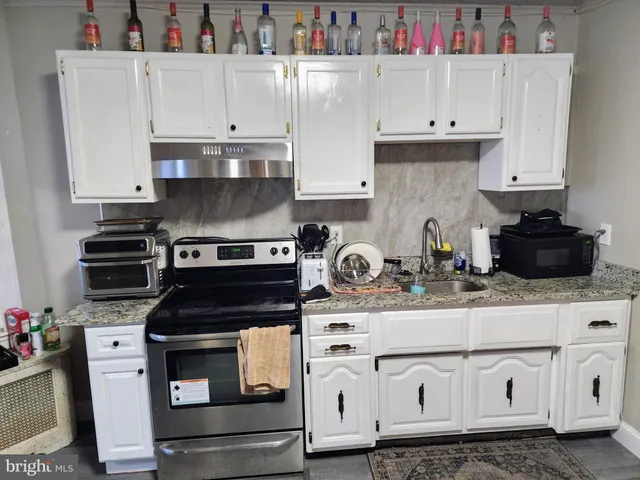 a kitchen with white cabinets and appliances