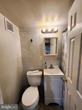 a bathroom with a toilet sink and mirror