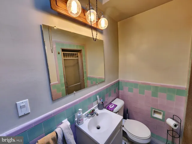 a bathroom with a sink vanity mirror and toilet