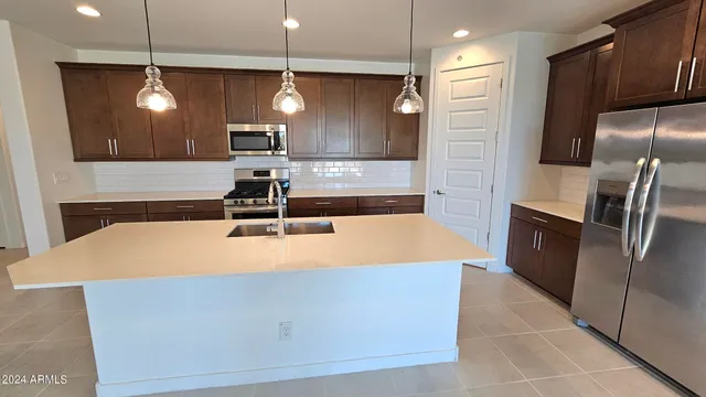 a large kitchen with a refrigerator a sink and a stove