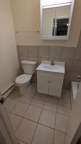 a bathroom with a toilet a sink and mirror