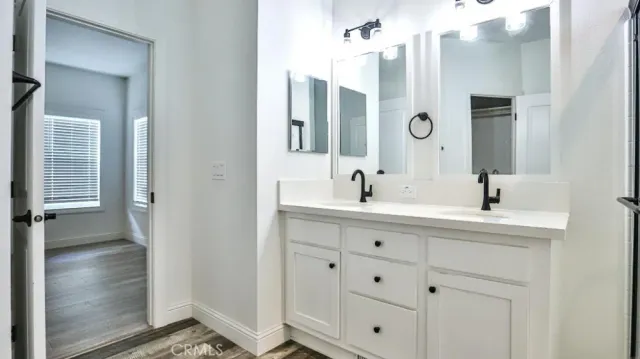 a bathroom with a double vanity sink a mirror and a shower