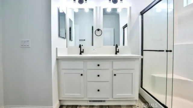 a bathroom with a bathtub sink vanity and mirror