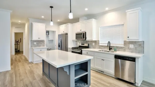 a kitchen with kitchen island a sink stove and refrigerator