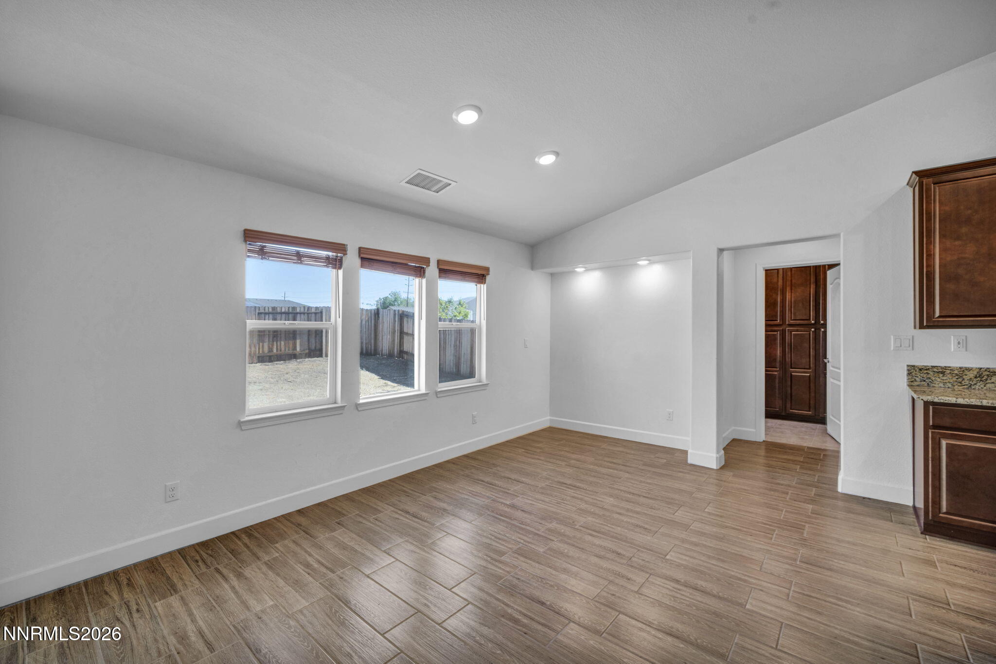 7181 Saddlehorn Road Carson City, NV 89701 - Photo 13 of 62 an empty room with wooden floor and a window