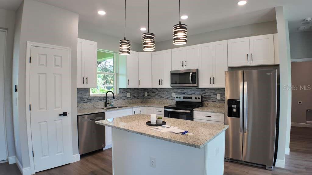 4200 Leaf Road Sebring, FL 33875 - Photo 3 of 9 a kitchen with a sink a counter space cabinets and stainless steel appliances