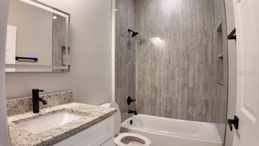 4200 Leaf Road Sebring, FL 33875 - Photo 7 of 9 a bathroom with a granite countertop sink and a mirror