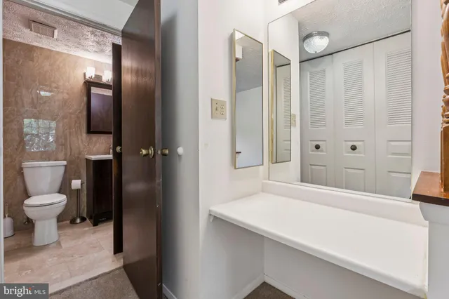a bathroom with a granite countertop sink toilet and shower