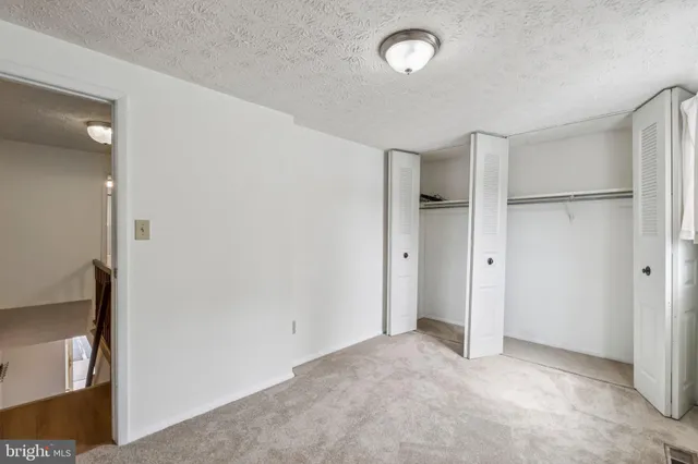 an empty room with closet and windows