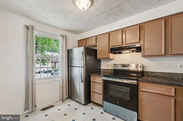 a kitchen with stainless steel appliances granite countertop a refrigerator stove and microwave