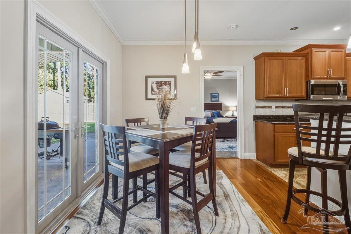 8756 Olivera Street Navarre, FL 32566 - Photo 11 of 41 a view of a dining room with furniture window and wooden floor