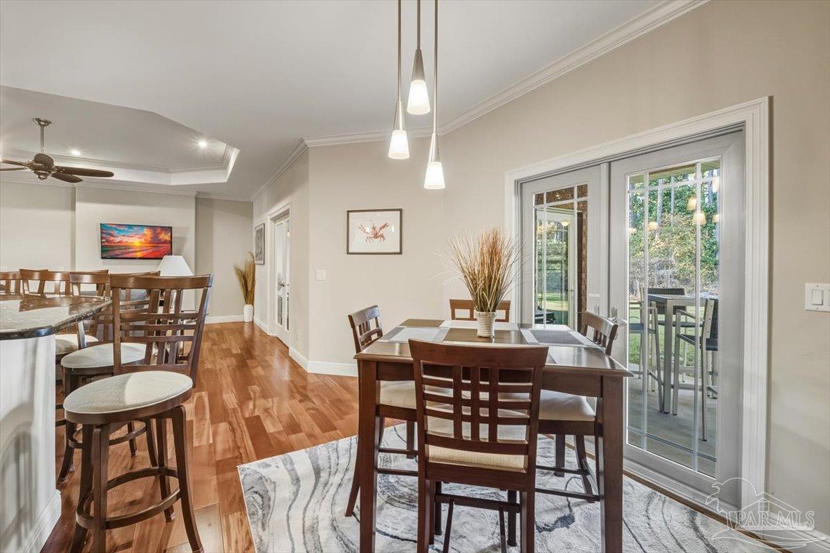 8756 Olivera Street Navarre, FL 32566 - Photo 13 of 41 a dining room with furniture a rug and a chandelier