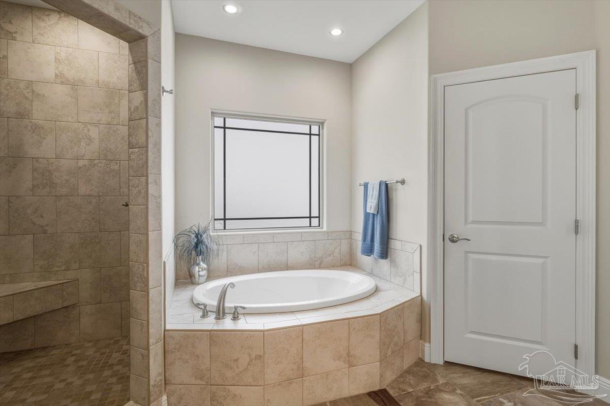 8756 Olivera Street Navarre, FL 32566 - Photo 24 of 41 a bathroom with a tub shower vanity and a sink