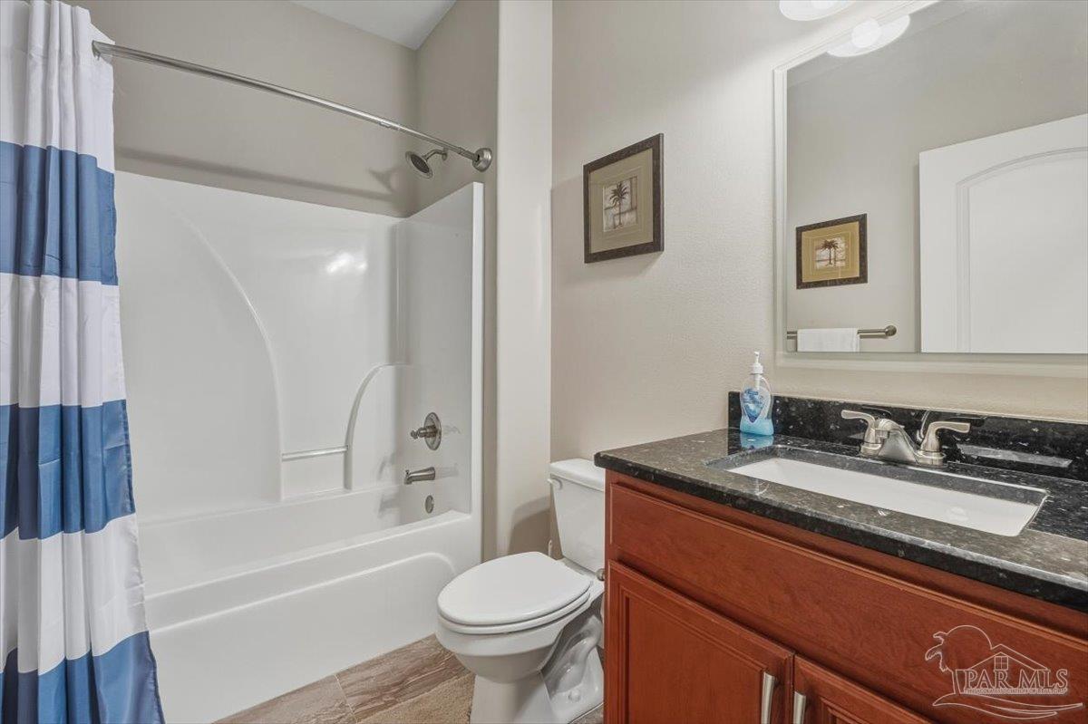 8756 Olivera Street Navarre, FL 32566 - Photo 31 of 41 a bathroom with a granite countertop sink toilet and shower