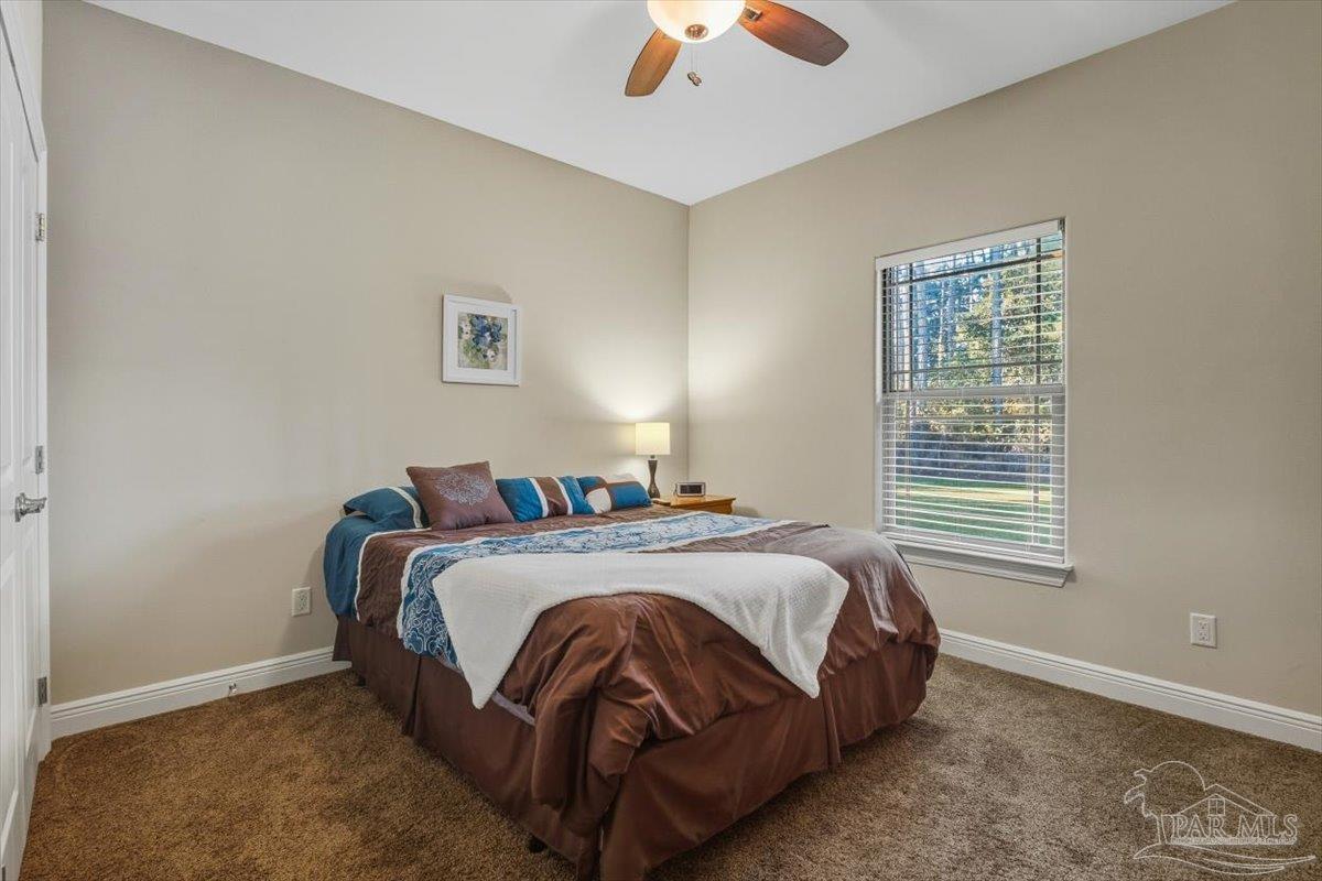 8756 Olivera Street Navarre, FL 32566 - Photo 32 of 41 a bedroom with a bed and a window
