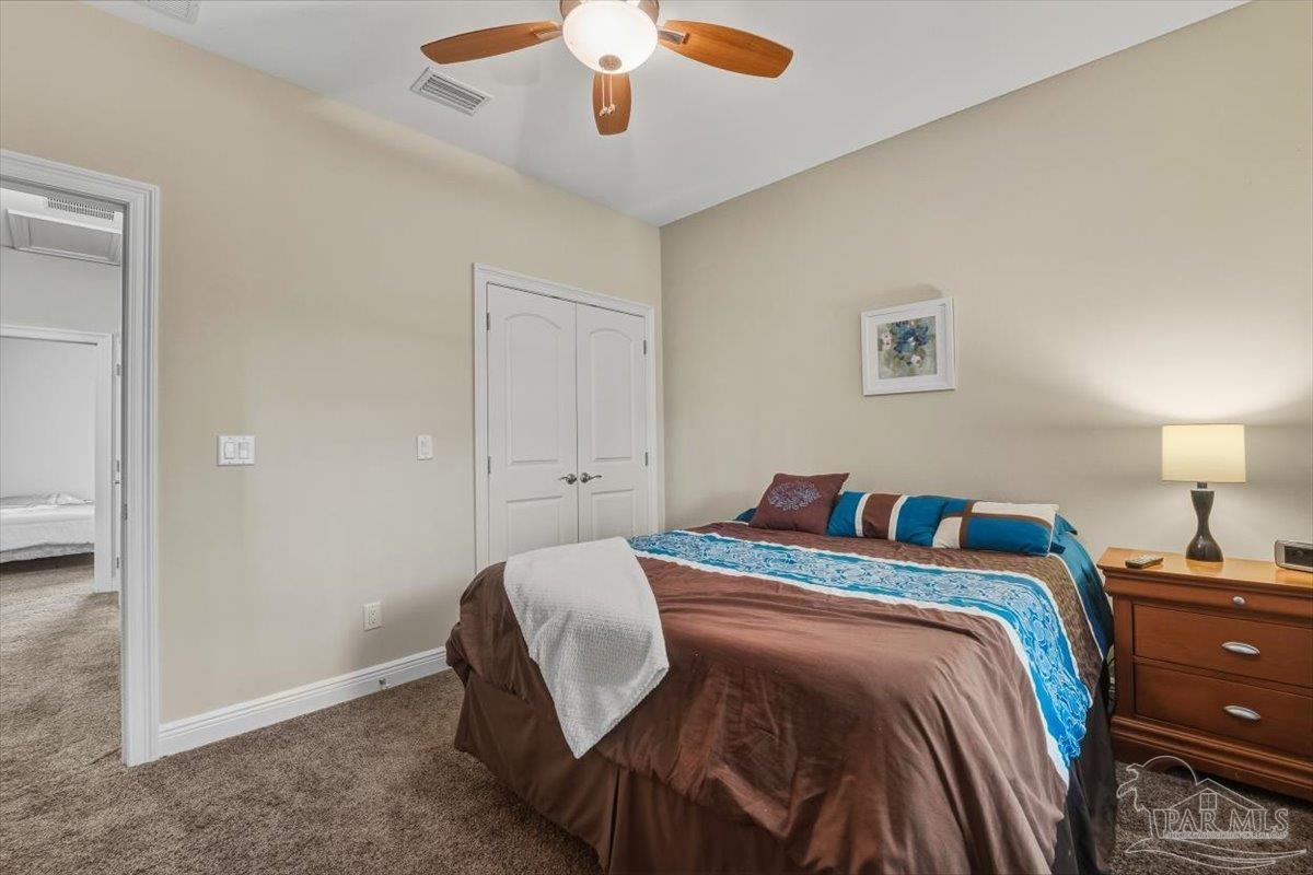 8756 Olivera Street Navarre, FL 32566 - Photo 34 of 41 a bedroom with a bed and a chandelier