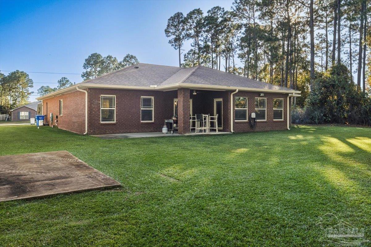 8756 Olivera Street Navarre, FL 32566 - Photo 38 of 41 a view of a house with a yard and sitting area