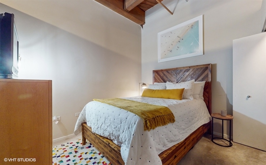 1040 West Adams Street, Unit 347 Chicago, IL 60607 - Photo 15 of 29 a bedroom with a bed and painting on the wall