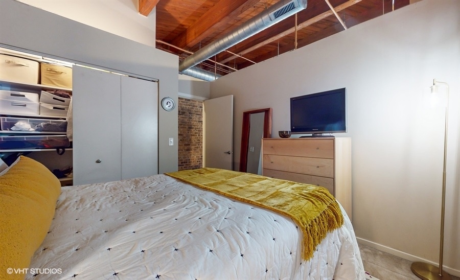 1040 West Adams Street, Unit 347 Chicago, IL 60607 - Photo 16 of 29 a bedroom with a bed and a flat screen tv