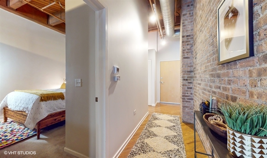 1040 West Adams Street, Unit 347 Chicago, IL 60607 - Photo 18 of 29 a view of a hallway to a livingroom with furniture and wooden floor