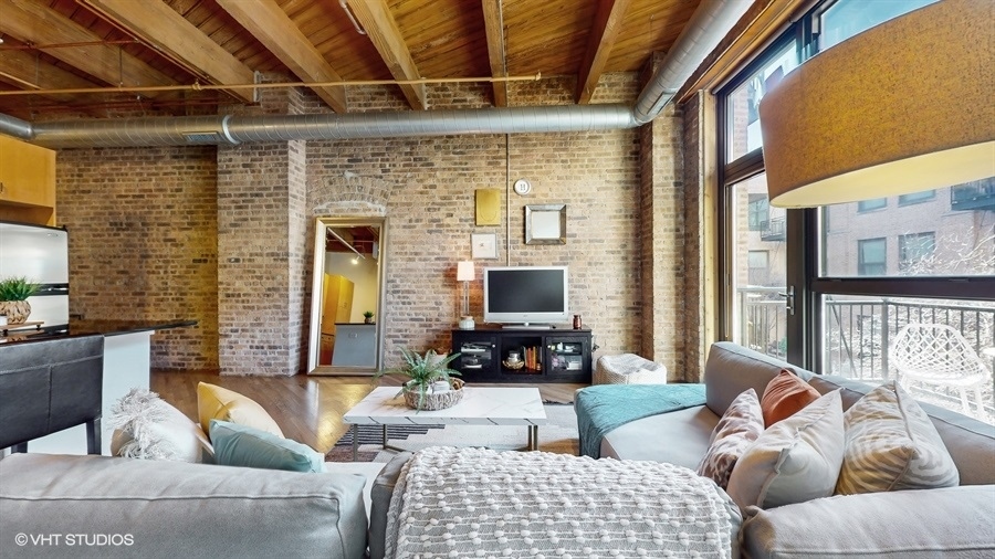 1040 West Adams Street, Unit 347 Chicago, IL 60607 - Photo 2 of 29 a living room with furniture and a flat screen tv