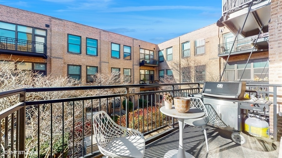 1040 West Adams Street, Unit 347 Chicago, IL 60607 - Photo 23 of 29 a view of a balcony with two chairs and a table