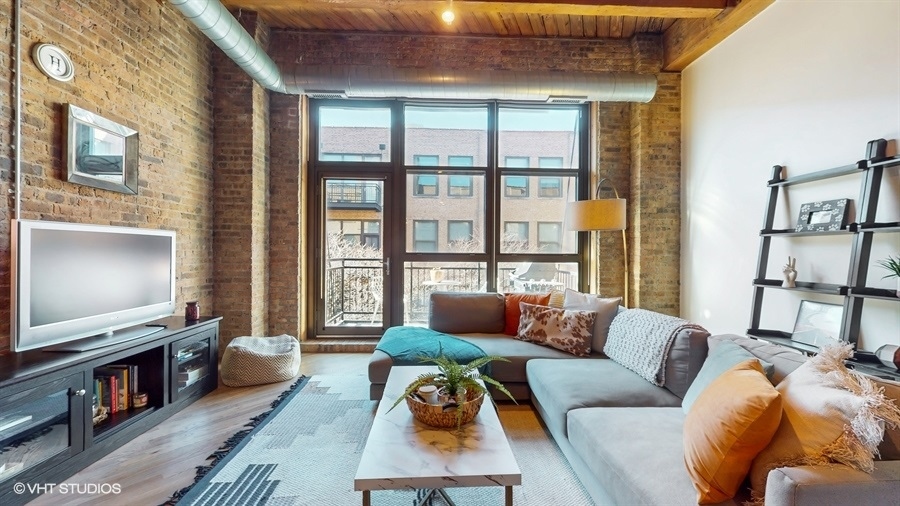 1040 West Adams Street, Unit 347 Chicago, IL 60607 - Photo 6 of 29 a living room with furniture a flat screen tv and a floor to ceiling window