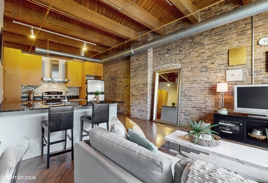 1040 West Adams Street, Unit 347 Chicago, IL 60607 - Photo 8 of 29 a living room with furniture and a flat screen tv