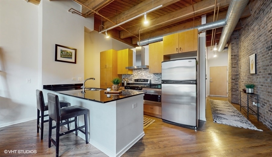 1040 West Adams Street, Unit 347 Chicago, IL 60607 - Photo 9 of 29 a kitchen with granite countertop a refrigerator and a stove