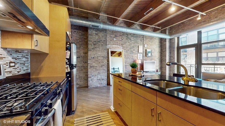 1040 West Adams Street, Unit 347 Chicago, IL 60607 - Photo 10 of 29 a kitchen with stainless steel appliances a sink and wooden cabinets