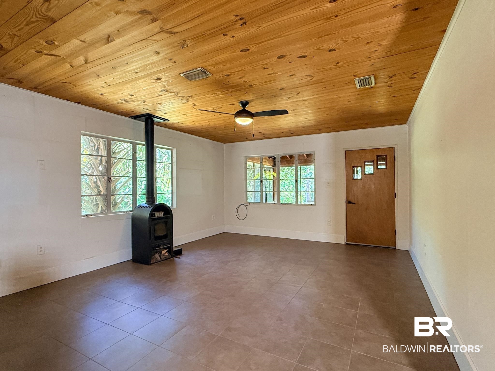 18711 Keller Road Foley, AL 36535 - Photo 4 of 38 Room featuring a wood-panel ceiling, large paneled windows, and tile flooring