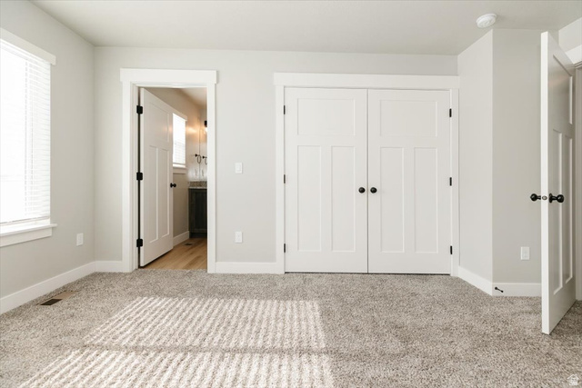 226 South 600 West Logan, UT 84321 - Photo 19 of 25 Unfurnished bedroom featuring light carpet, a closet, and ensuite bath