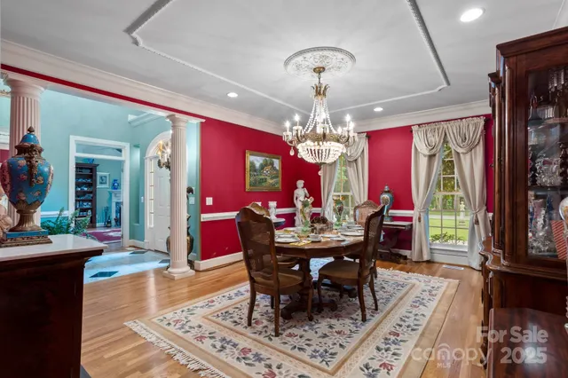 a view of a dining room with furniture a chandelier and wooden floor