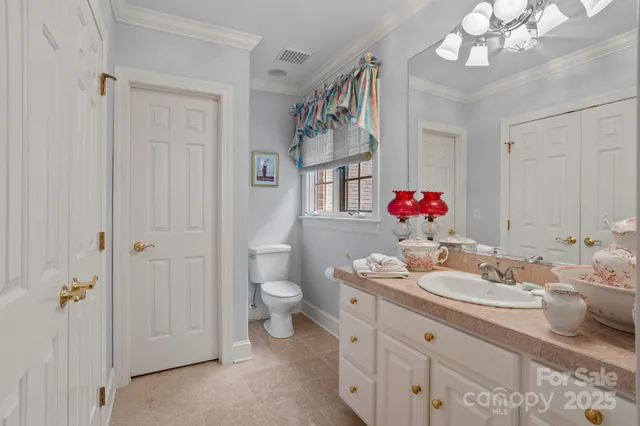 a bathroom with a sink vanity mirror and toilet