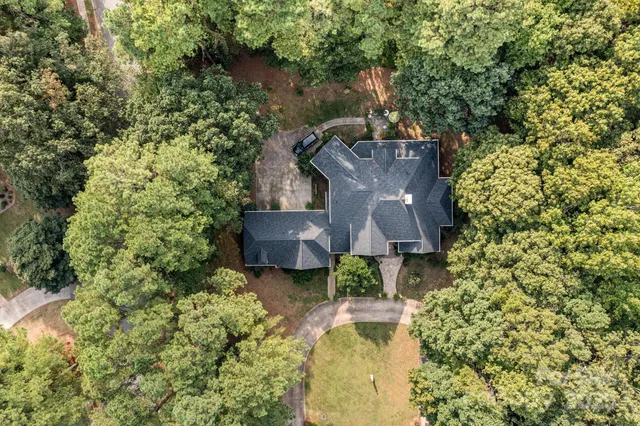 an aerial view of a house with swimming pool and garden