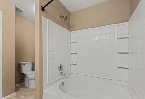 a bathroom with a bathtub and a toilet
