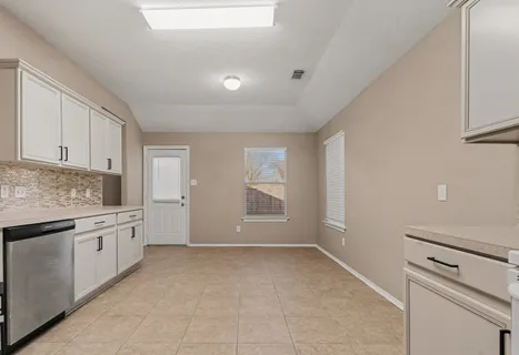 a kitchen with granite countertop white cabinets and white appliances