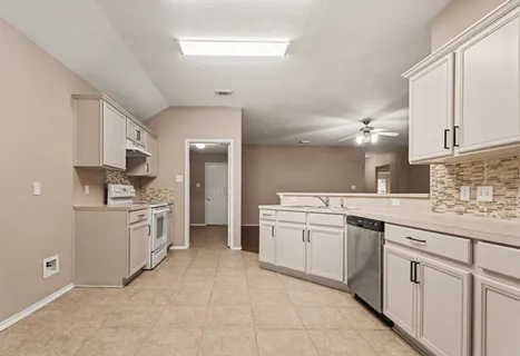 a kitchen with a sink stove and cabinets