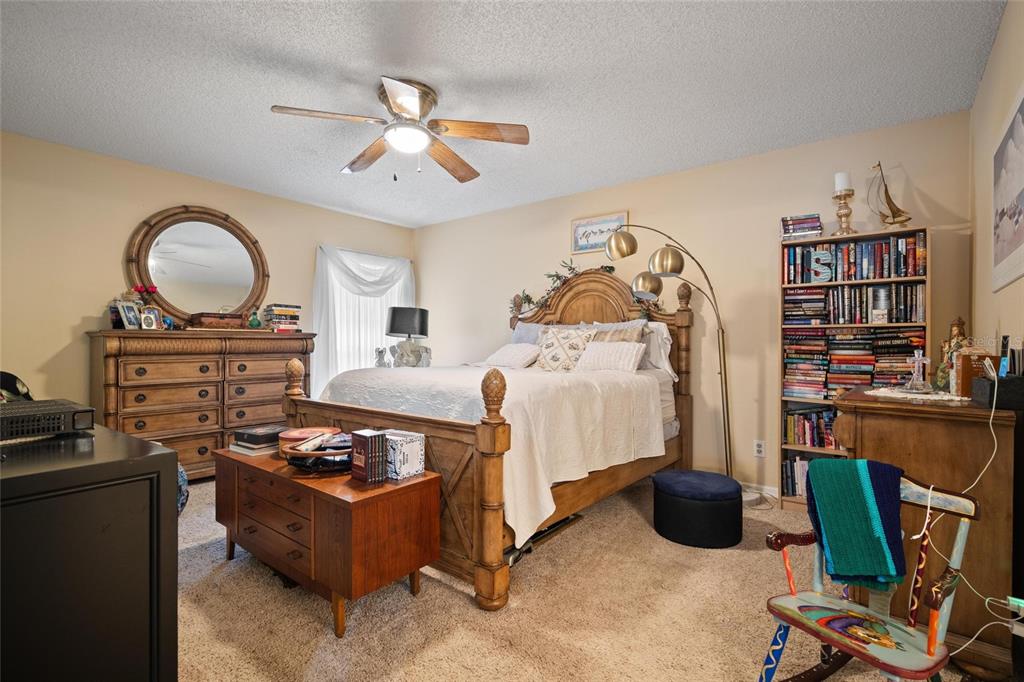 1801 East Lake Road South, Unit 5A Palm Harbor, FL 34685 - Photo 16 of 22 a bedroom with furniture and a chandelier