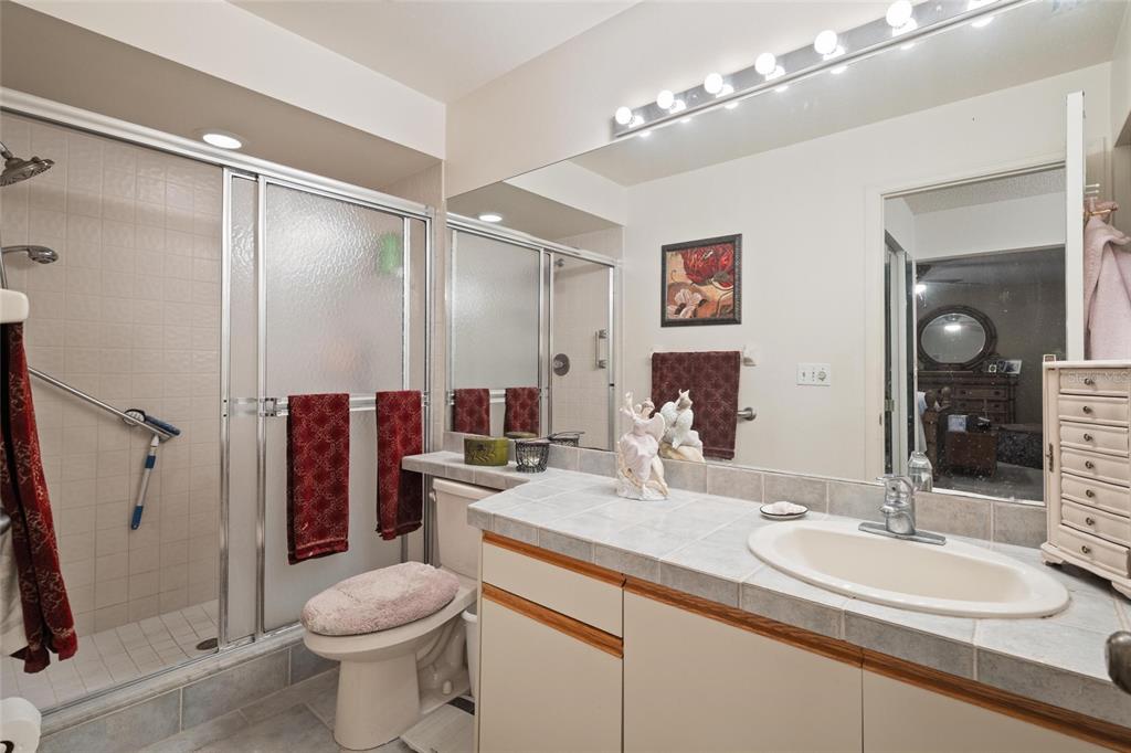 1801 East Lake Road South, Unit 5A Palm Harbor, FL 34685 - Photo 18 of 22 a bathroom with a sink vanity granite and toilet