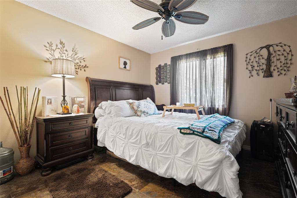 1801 East Lake Road South, Unit 5A Palm Harbor, FL 34685 - Photo 20 of 22 a bedroom with a bed and a chandelier