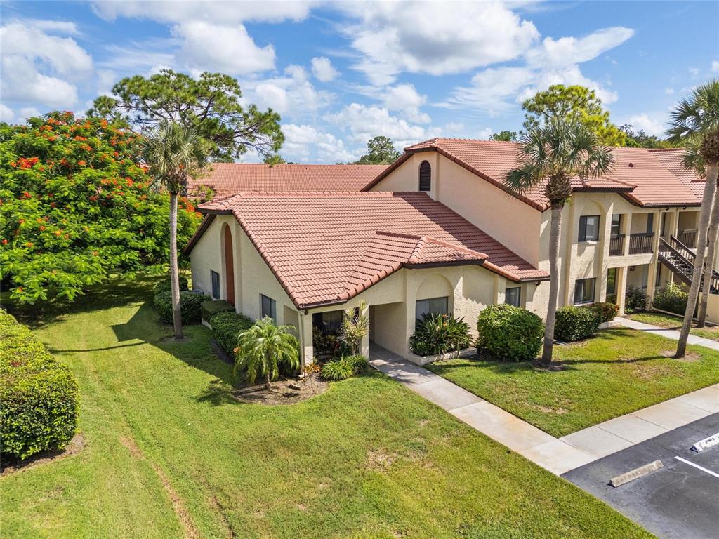 1801 East Lake Road South, Unit 5A Palm Harbor, FL 34685 - Photo 2 of 22 a view of a white house with a big yard and potted plants