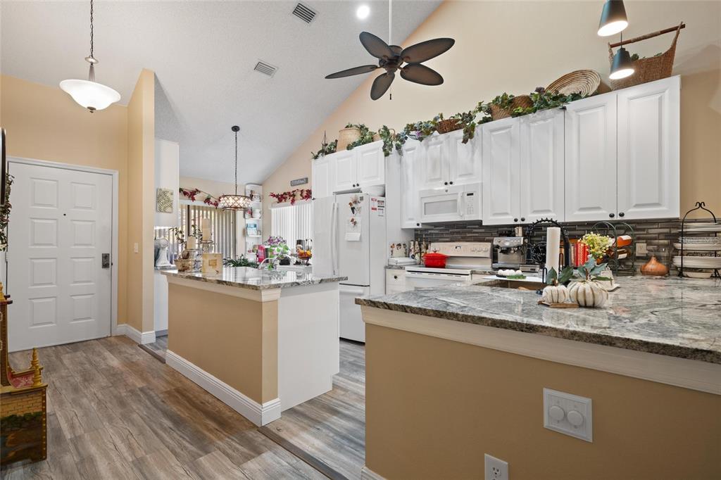 1801 East Lake Road South, Unit 5A Palm Harbor, FL 34685 - Photo 6 of 22 a kitchen with stainless steel appliances granite countertop a sink a stove and a refrigerator