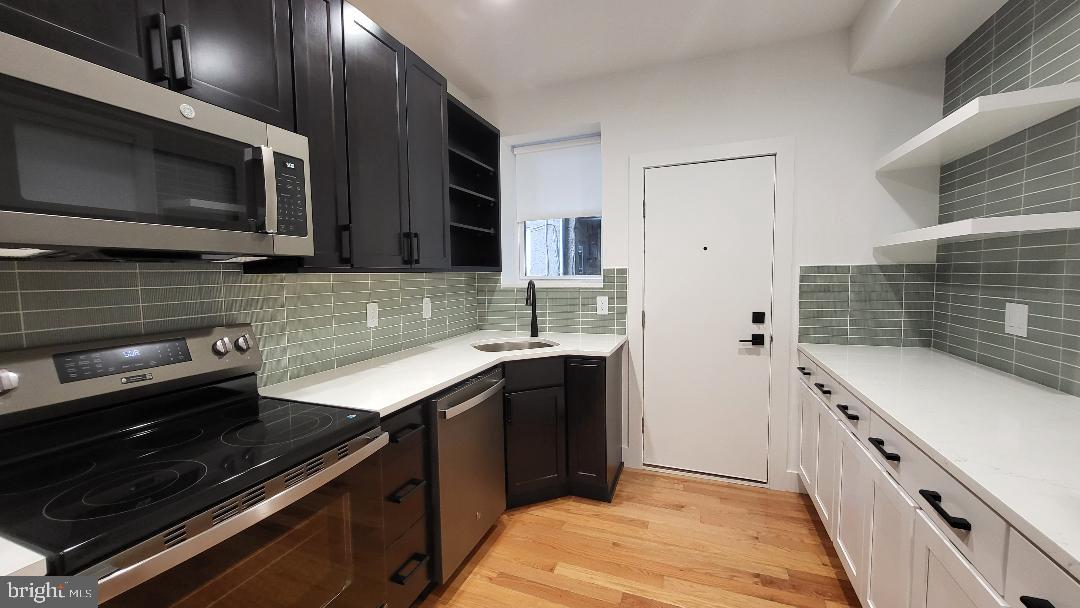 1237 South 27th Street Philadelphia, PA 19146 - Photo 9 of 36 a kitchen with a sink stove and microwave