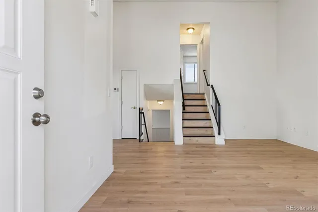 a view of a hallway with wooden floor and staircase