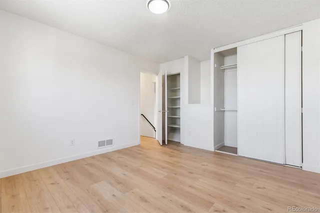 a view of empty room with wooden floor