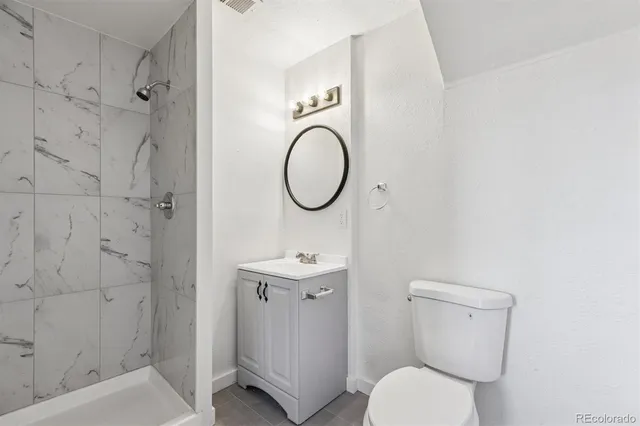 a bathroom with a toilet sink vanity tub and shower