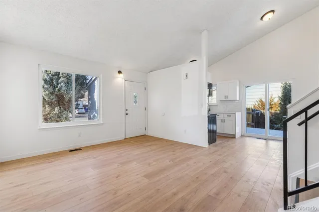a view of a big room with wooden floor and windows