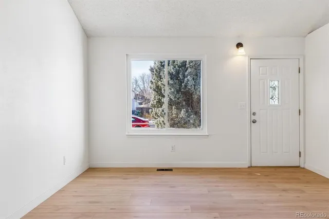 a view of an empty room with window and closet